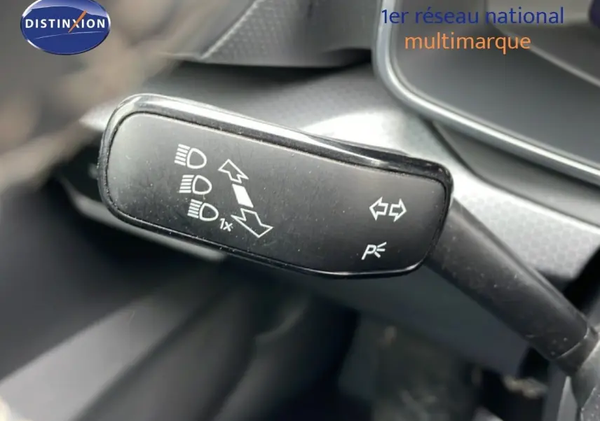 Gros plan sur la manette de clignotants intérieure du SEAT LEON 2025 gris magnétique, avec pictogrammes blancs visibles.