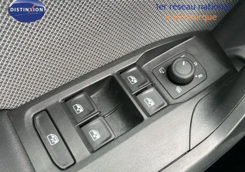 Gros plan sur les commandes des vitres électriques et rétroviseurs côté conducteur d'une SEAT Leon gris magnétique 2025.