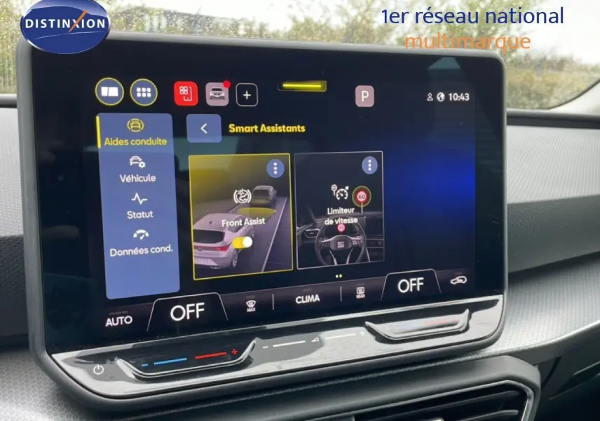 Écran tactile central affichant les aides à la conduite dans l’habitacle d’une SEAT LEON gris magnétique, vue de face.