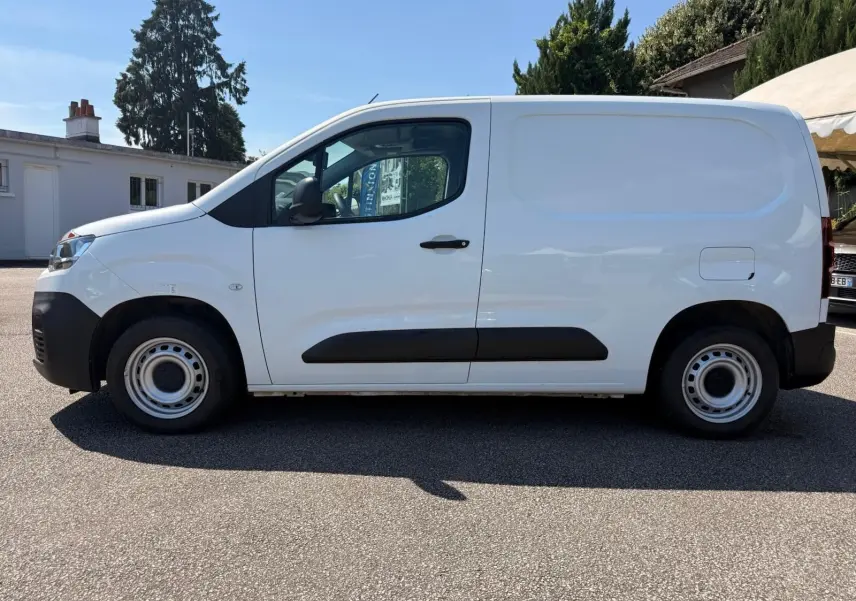 Vue de profil côté gauche d’un utilitaire Citroën Berlingo Van blanc avec porte latérale et jantes acier simples.