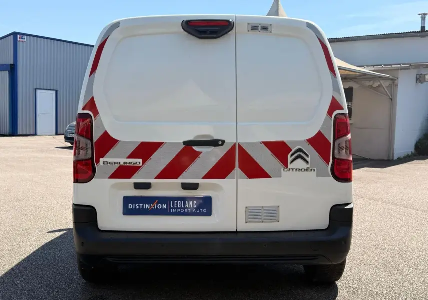 Vue arrière d’un utilitaire blanc Citroën Berlingo Van 2020 avec bandes réfléchissantes rouges et blanches.