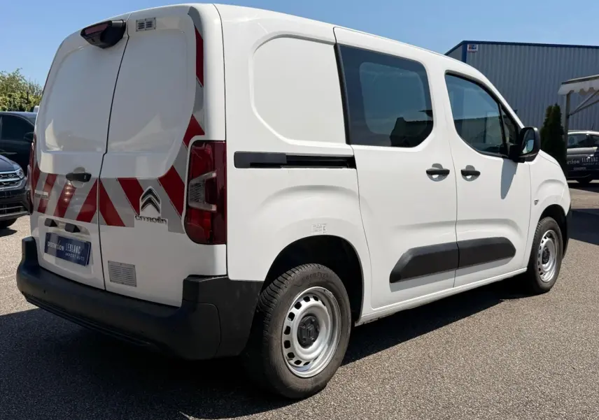 Vue 3/4 arrière droite d'un Citroën Berlingo Van blanc 2020 avec bandes rouges réfléchissantes sur les portes arrière.