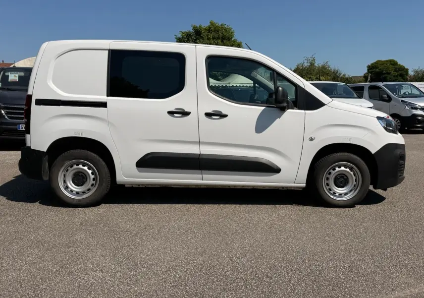 Vue de profil côté droit d'un utilitaire Citroën Berlingo Van blanc avec porte latérale coulissante et jantes acier.