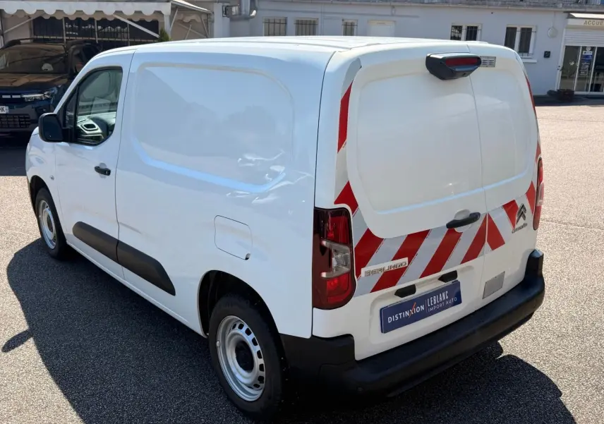 Vue 3/4 arrière droite d'un Citroën Berlingo Van blanc 2020 avec bandes réfléchissantes rouges sur les portes arrière.