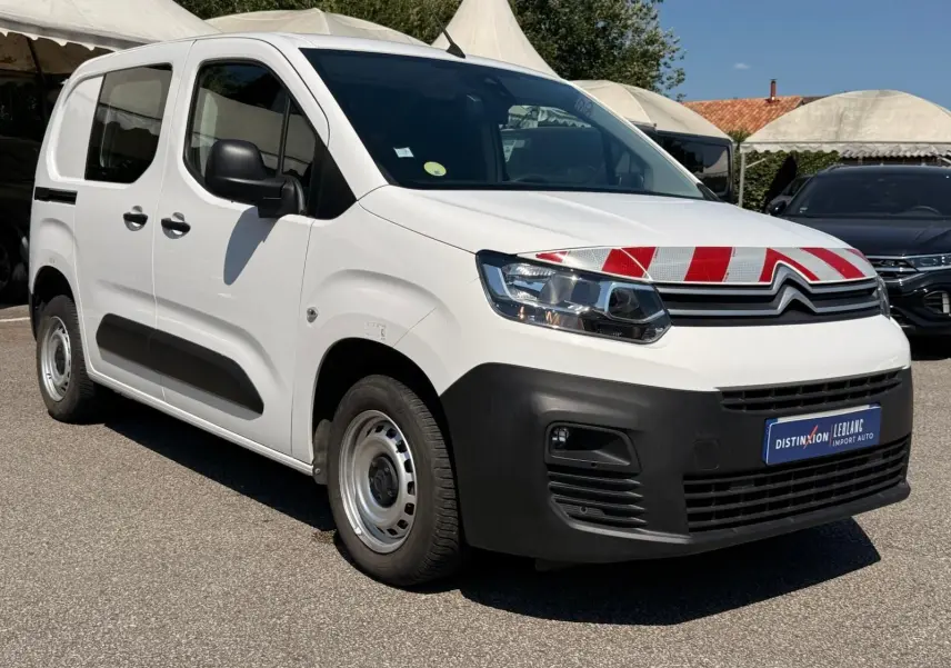 Vue 3/4 avant droit d'un Citroën Berlingo Van blanc 2020 avec marquage rouge et blanc sur le capot et pare-chocs noir.