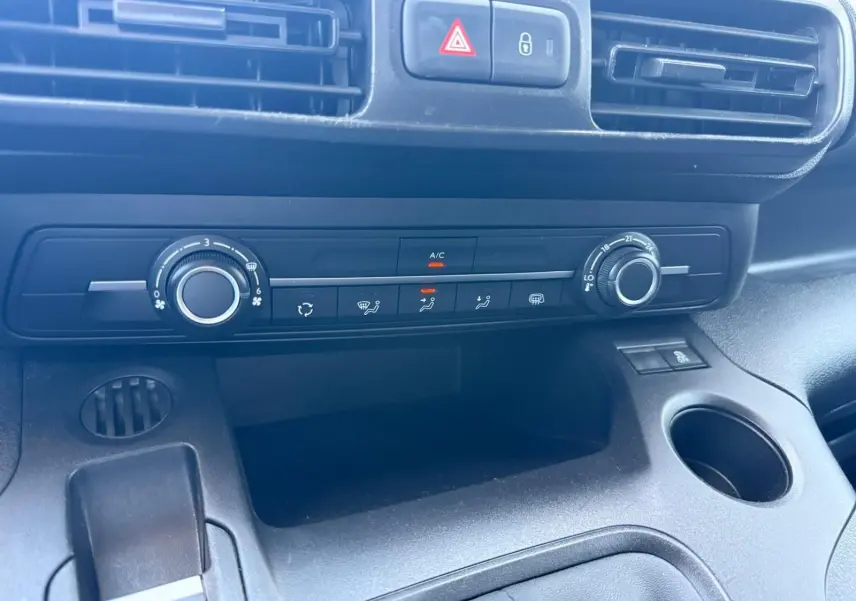 Vue rapprochée du tableau de bord noir du Citroën Berlingo Van 2020, montrant les commandes de climatisation et les aérateurs.