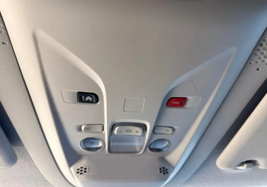 Vue en gros plan du plafonnier gris clair avec boutons de commande et alerte SOS dans un Citroën Berlingo blanc 2020.