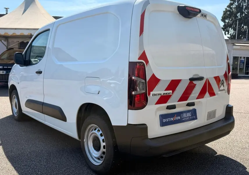 Vue 3/4 arrière droite d’un Citroën Berlingo Van blanc avec bandes rouges réfléchissantes sur les portes arrière.