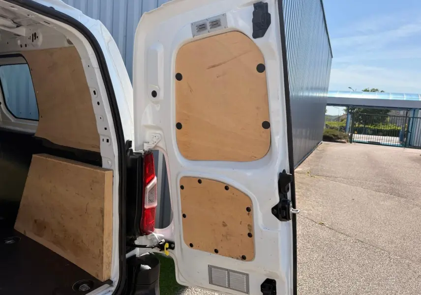 Vue arrière droite ouverte d’un Citroën Berlingo Van blanc 2020 avec aménagement bois intérieur des portes et du coffre.