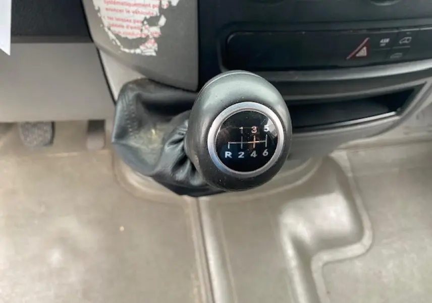 Gros plan sur le levier de vitesses manuel noir du Mercedes Sprinter Fourgon blanc de 2015.