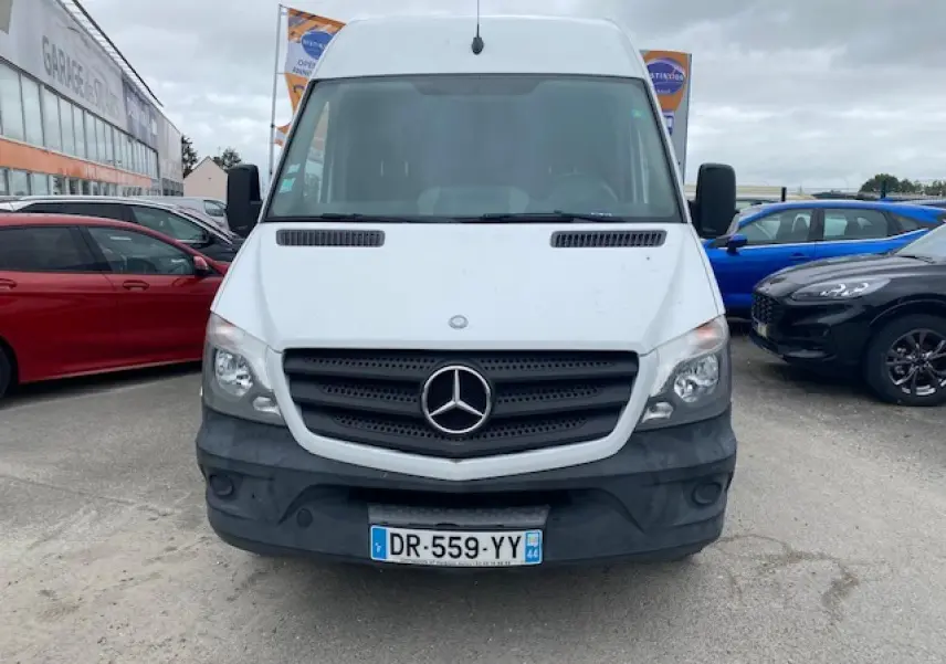Vue frontale d'un Mercedes Sprinter blanc avec calandre noire et plaque d'immatriculation française visible.