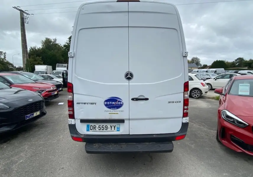 Vue arrière d'un Mercedes Sprinter fourgon blanc de 2015 avec plaques françaises et logo Distinxion visible.