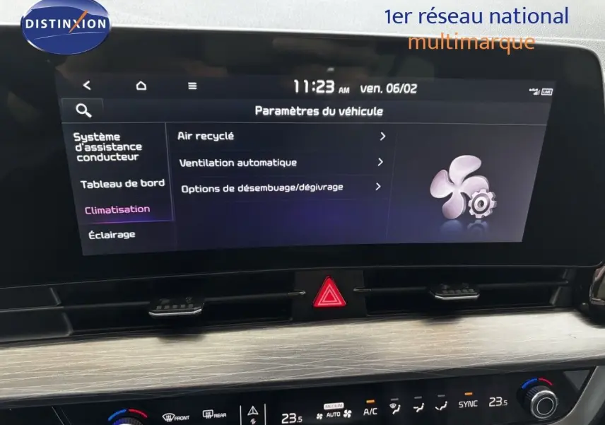 Écran tactile central et commandes de climatisation du Kia Sportage blanc nacré, vue intérieure frontale rapprochée.