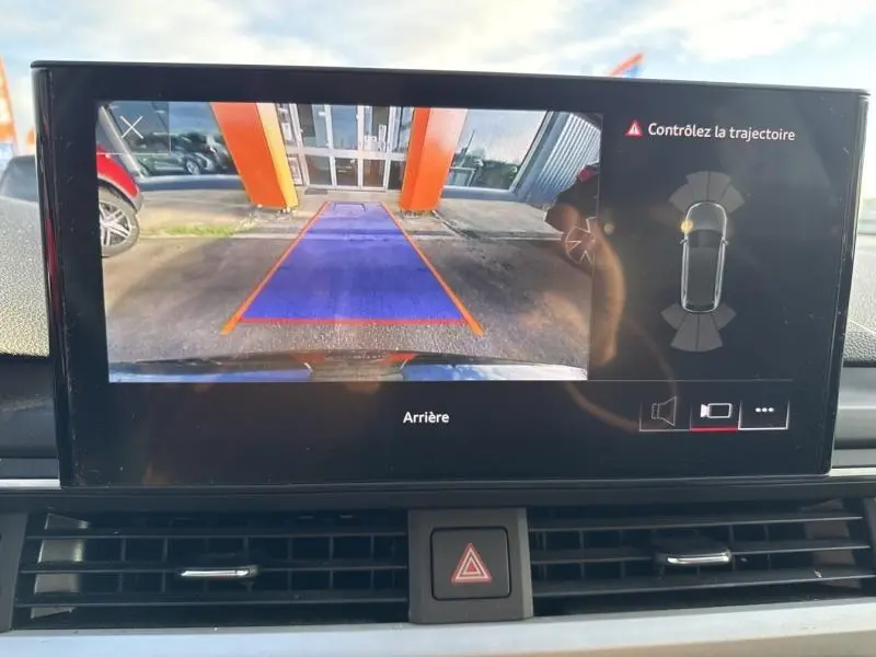Vue de l'écran de caméra de recul d'une Audi A4 Avant noire, affichant la zone arrière avec repères de trajectoire.