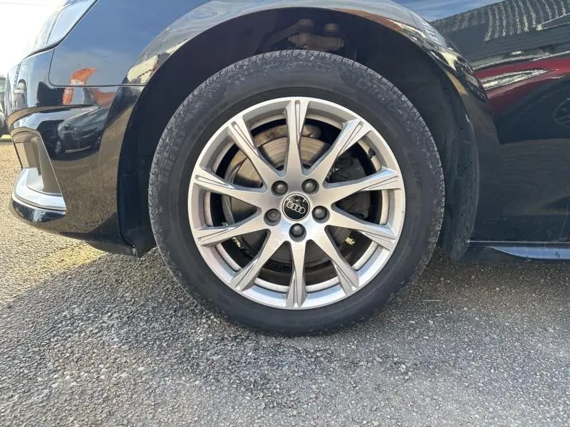 Gros plan sur la roue avant gauche avec jante alu 10 branches de l'Audi A4 Avant noir brillant 2022.