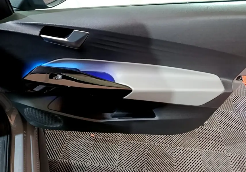 Vue intérieure du panneau de porte côté conducteur du Volkswagen ID.3 77 kWh Pro S avec éclairage d'ambiance bleu et garniture bicolore.