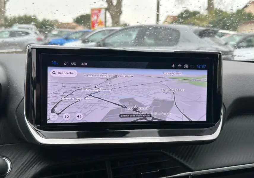 Écran tactile central affichant la navigation GPS dans l'habitacle du Peugeot 2008 gris, vue de face.