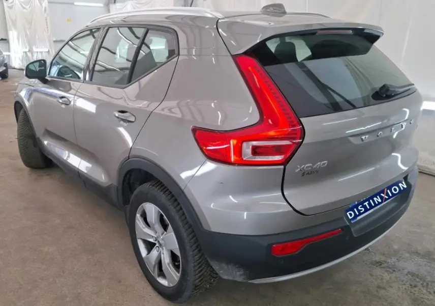 Vue 3/4 arrière droite du Volvo XC40 marron clair avec feux arrière LED caractéristiques et jantes alliage.