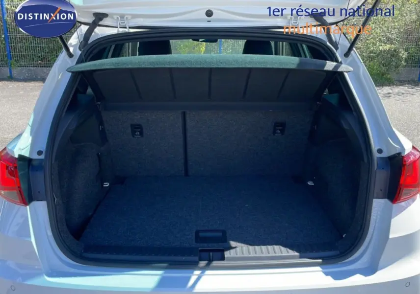 Coffre ouvert vu de l'arrière d'un SEAT Arona blanc avec toit noir, montrant l'espace de chargement vide.