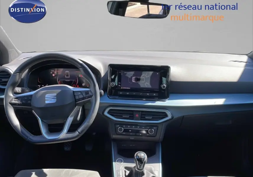 Intérieur avant du SEAT Arona 2025, tableau de bord noir avec écran tactile et volant multifonction.
