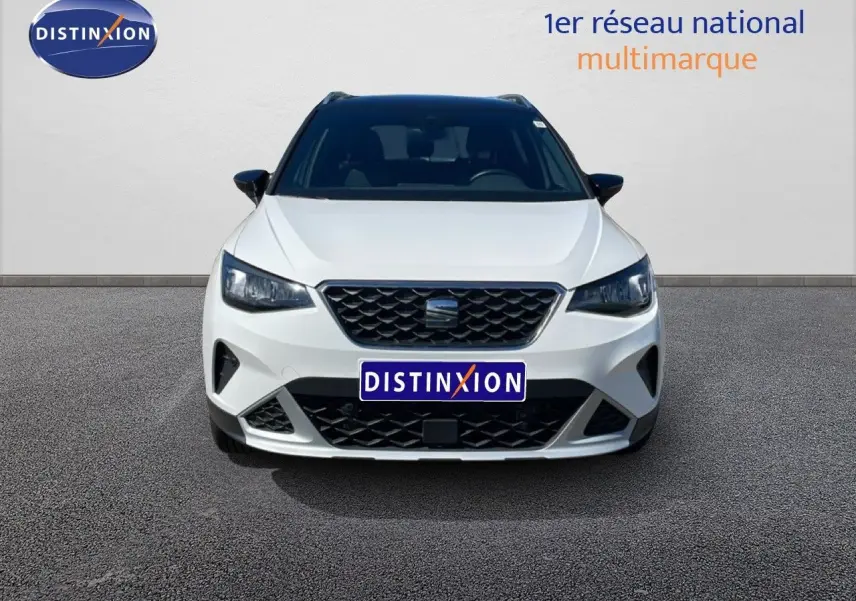 Vue avant du SEAT Arona blanc avec toit noir, mettant en valeur sa calandre distinctive et ses phares LED.