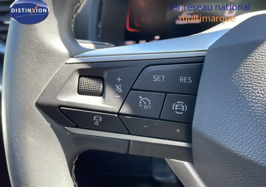Gros plan sur les commandes au volant côté gauche du SEAT Arona 2025, volant cuir avec boutons de régulateur de vitesse.