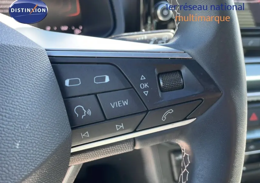 Gros plan sur les commandes au volant cuir du SEAT Arona 2025, mettant en valeur les boutons multifonctions côté gauche.