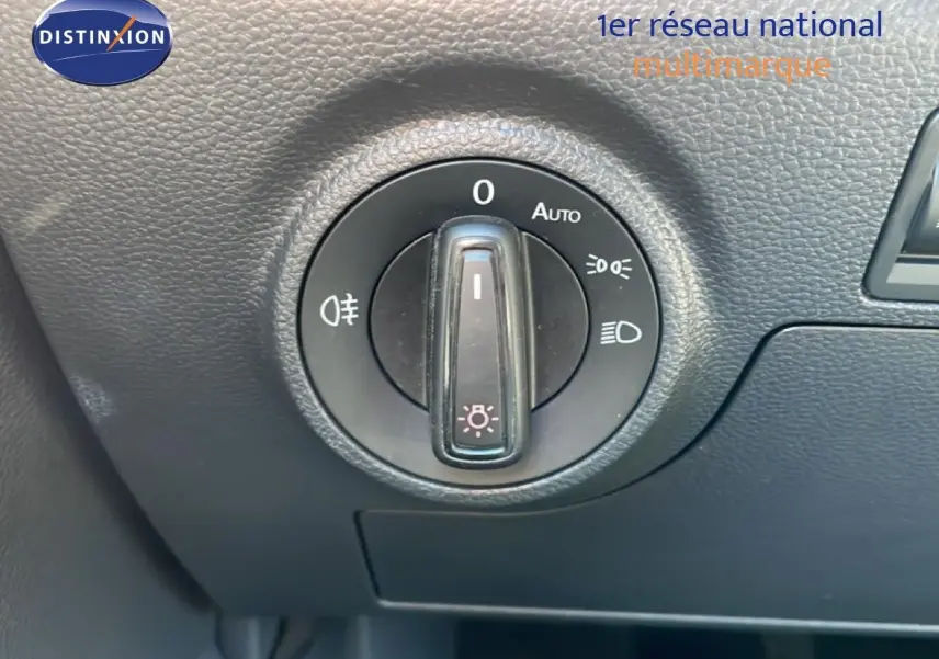 Gros plan sur le bouton de commande des phares du tableau de bord du SEAT Arona 2025 blanc toit noir.