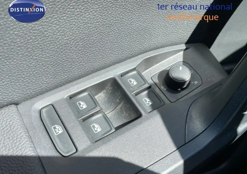 Gros plan sur les commandes électriques des vitres et rétroviseurs côté conducteur d’un SEAT Arona blanc toit noir.