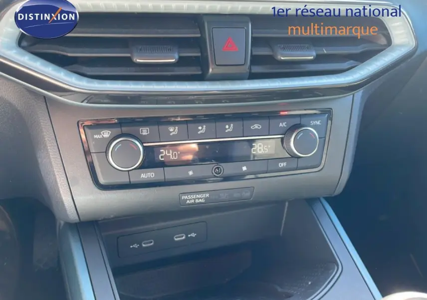 Vue rapprochée de la console centrale du SEAT Arona 2025, avec commandes de climatisation digitales et prises USB visibles.