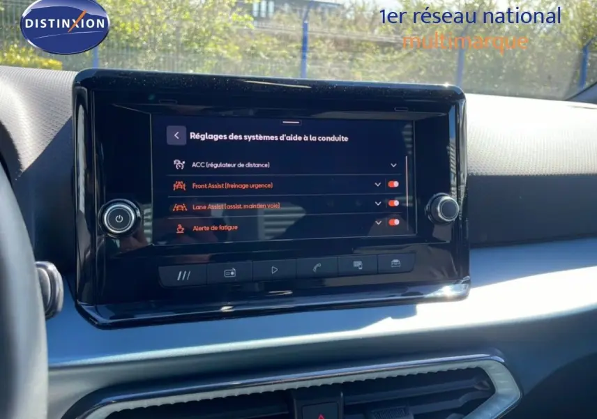 Vue intérieure centrée sur l'écran tactile du tableau de bord du SEAT Arona 2025, affichant les aides à la conduite.
