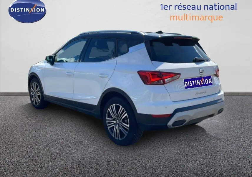 Vue 3/4 arrière droite d'un SEAT Arona blanc à toit noir avec jantes alliage et feux LED distinctifs.