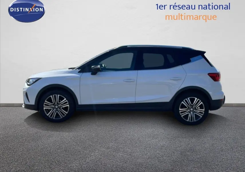 Vue de profil droit d'un SEAT Arona blanc avec toit noir, roues alliage et lignes modernes sur fond neutre.