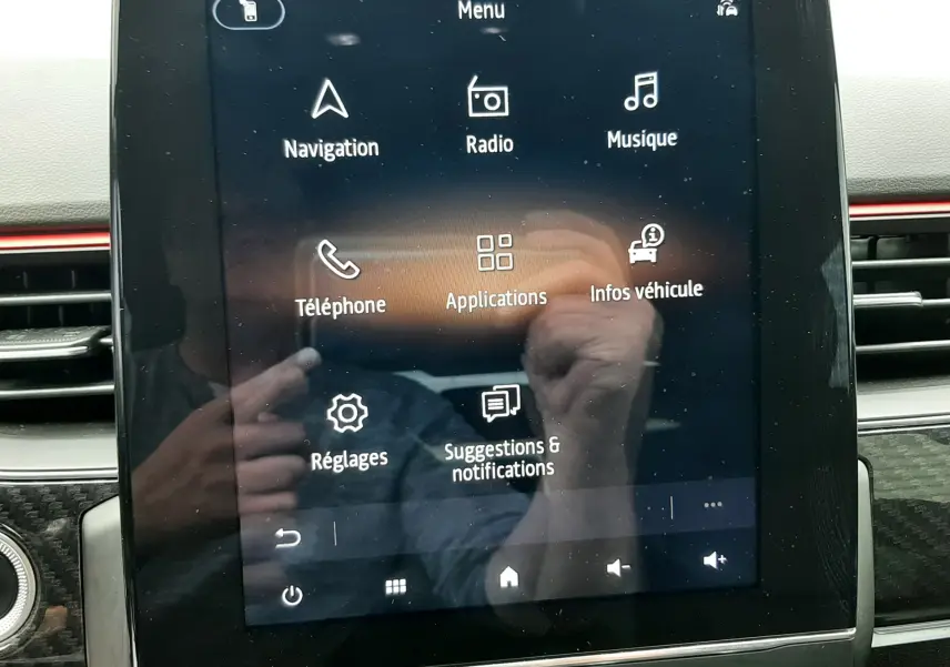 Écran tactile central du tableau de bord de la Renault Arkana E-Tech, affichant le menu principal avec options multimédia et navigation.