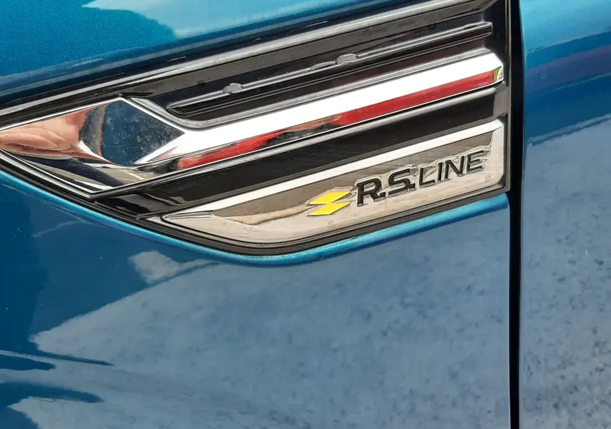 Détail du badge R.S. Line sur la porte côté gauche d'une Renault Arkana Bleu Zanzibar 2021.