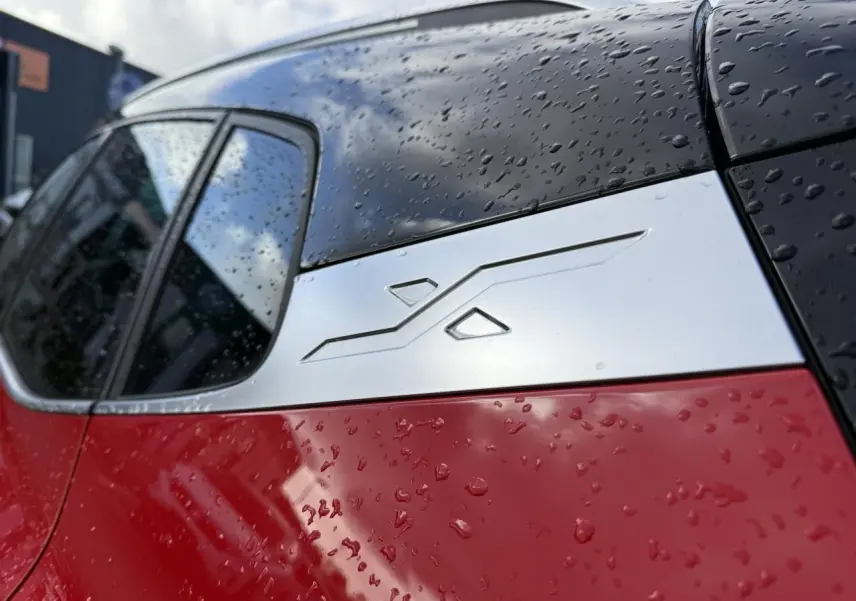 Détail du montant arrière droit rouge et noir du SEAT Arona 2024 avec insert décoratif argenté sous la pluie.
