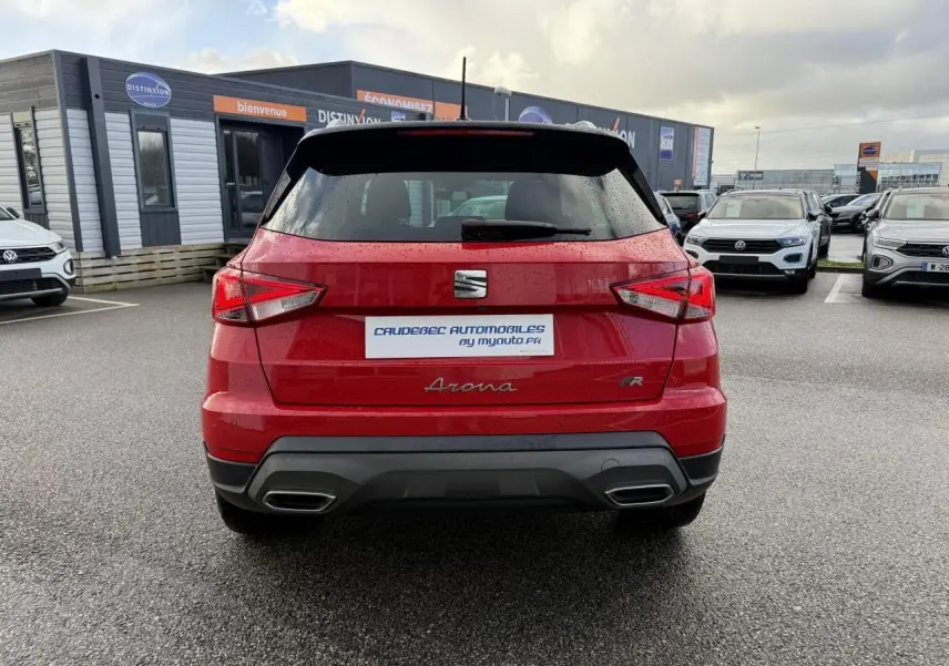 Vue arrière d'un SEAT Arona rouge 2024 avec logo FR et double sortie d'échappement intégrée au pare-chocs noir.
