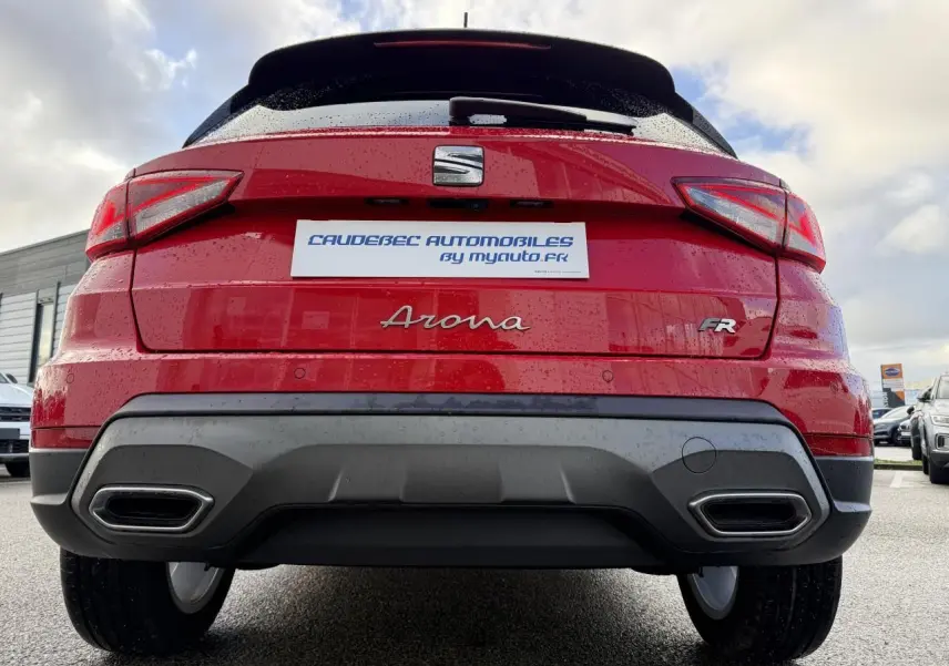 Vue arrière d'une SEAT Arona rouge 2024 avec logo FR et double sortie d'échappement intégrée au pare-chocs.