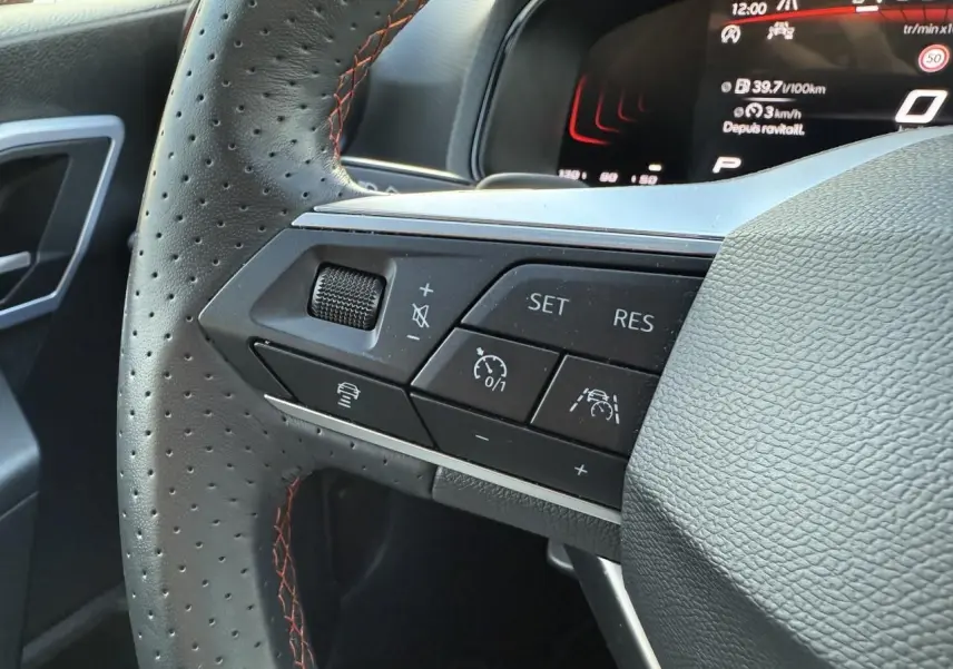 Gros plan sur le volant sport en cuir perforé avec surpiqûres rouges et commandes multifonctions du SEAT Arona 2024.
