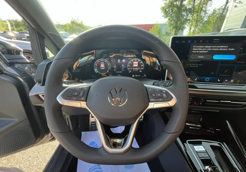 Vue intérieure centrée sur le volant cuir multifonctions d'une Volkswagen Golf gris dauphin avec tableau de bord numérique.