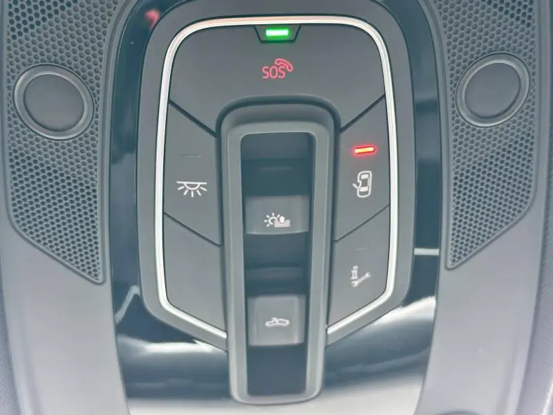 Gros plan sur la console de plafonnier noir brillant de l'Audi A6 Avant 45 TDI avec boutons SOS et éclairage intérieur.