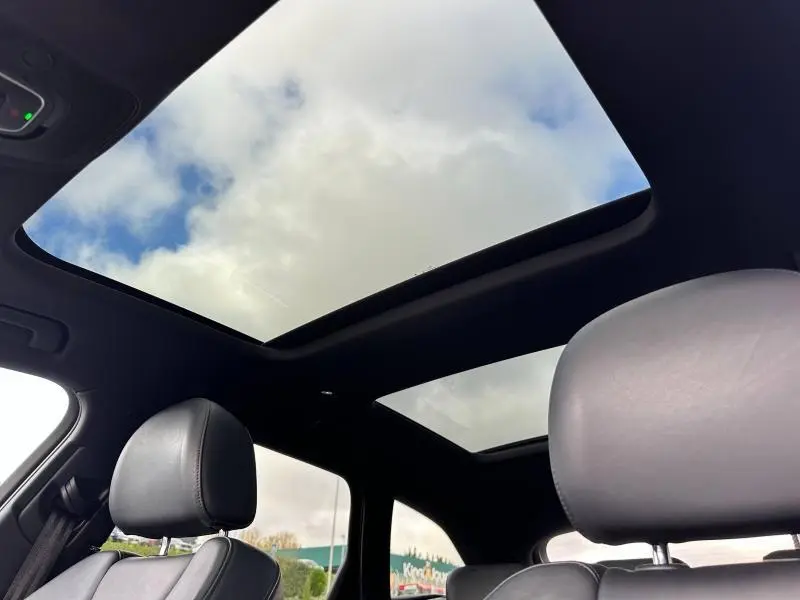 Toit panoramique ouvert vu de l'intérieur sur les sièges cuir noirs de l'Audi A6 Avant noir métal 2019
