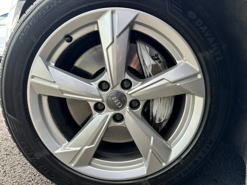Gros plan sur la jante alu argentée de l'Audi A6 Avant 45 TDI 2019 avec logo Audi au centre et disque de frein visible
