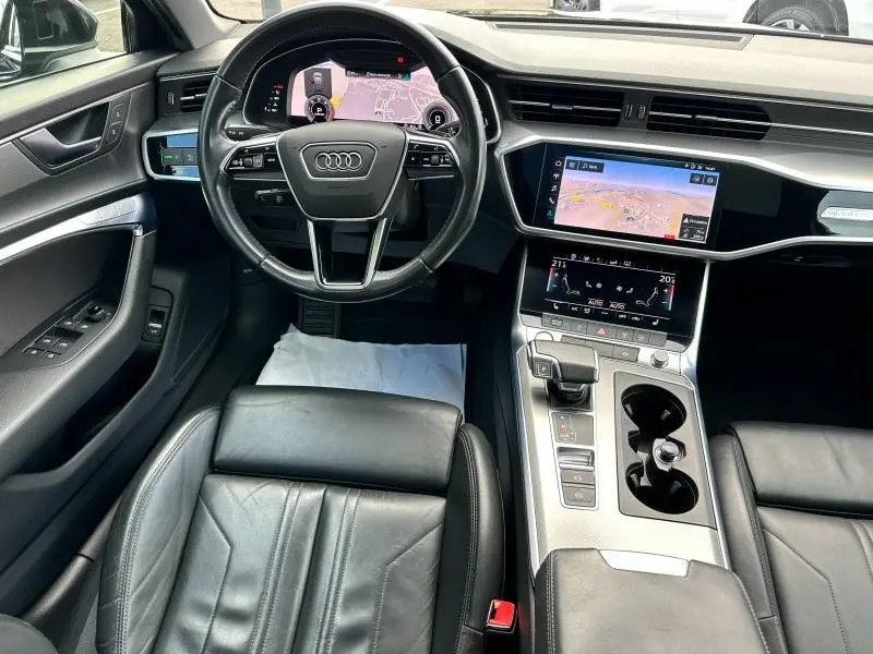 Intérieur noir cuir de l'Audi A6 Avant 45 TDI 2019, vue du poste de conduite avec écran tactile et volant multifonction.