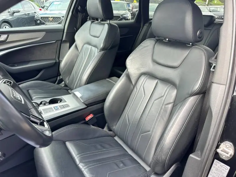 Intérieur de l'Audi A6 Avant 45 TDI 2019, vue côté gauche sur sièges sport cuir noir et console centrale.