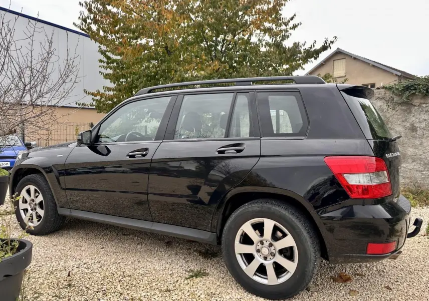 Mercedes GLK 220 CDI noir vu de profil côté gauche, avec barres de toit et jantes alliage visibles