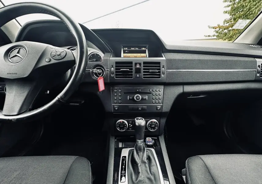 Intérieur noir de Mercedes GLK 220 CDI 2010, vue frontale sur tableau de bord et levier de boîte automatique.