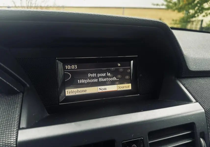 Écran central du tableau de bord Mercedes GLK 220 CDI 2010 affichant la connexion Bluetooth, vue intérieure frontale.
