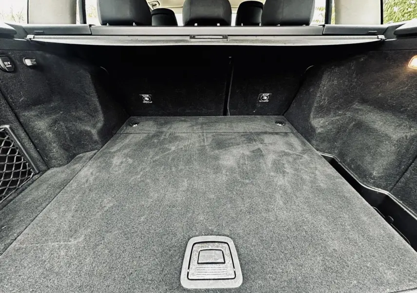 Coffre noir spacieux de Mercedes GLK 220 CDI 4-Matic vu de l'arrière avec cache-bagages et sièges rabattus.