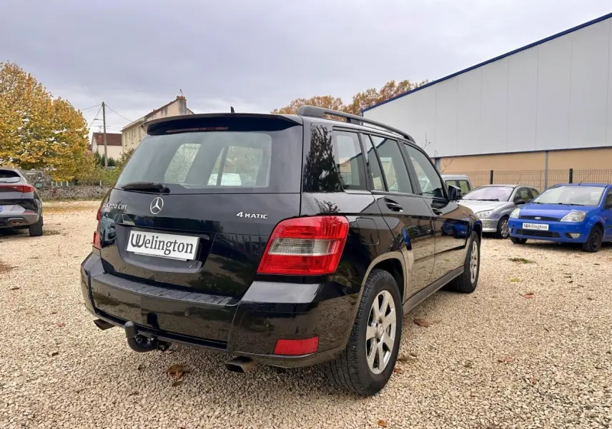 Vue 3/4 arrière droite d'un Mercedes GLK 220 CDI noir avec attelage et logo 4MATIC visible.